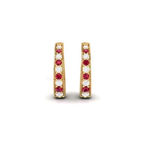 May include: A pair of gold-coloured hoop earrings. Each earring features alternating red and white gemstones. The earrings have a textured design along the edges, creating a classic look. The gemstones are evenly spaced. The earrings are suitable for everyday wear.