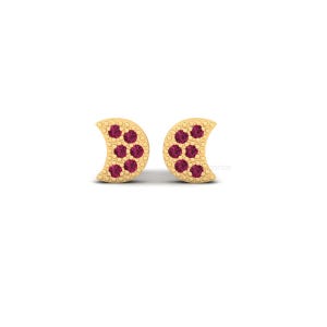 May include: A pair of gold-colored crescent moon stud earrings. Each earring features a crescent shape with a pattern of seven small, round, red gemstones. The earrings are set against a white background.
