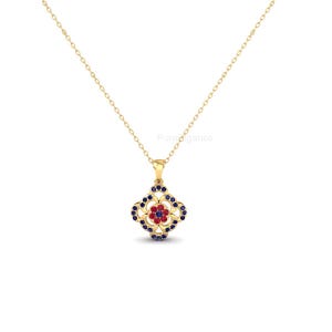 May include: A gold-colored necklace with a pendant featuring a floral design. The pendant has a red center surrounded by blue and gold accents. The necklace is displayed on a white background.