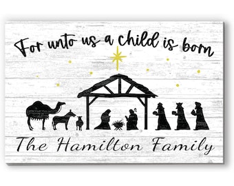 May include: A wooden sign with a white background and black text that reads "For unto us a child is born." The sign features a nativity scene with silhouettes of a camel, donkey, and figures. The text "The Hamilton Family" is below the scene.
