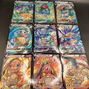 Könnte beinhalten: Eine Sammlung von neun Sammelkarten in einem drei-mal-drei Raster, die jeweils eine Pokémon-Figur im farbenfrohen Buntglas-Stil zeigen. Die Karten umfassen Bulbasaur, Ivysaur, Venusaur, Squirtle, Wartortle, Blastoise, Charmander, Charmeleon und Charizard V.
