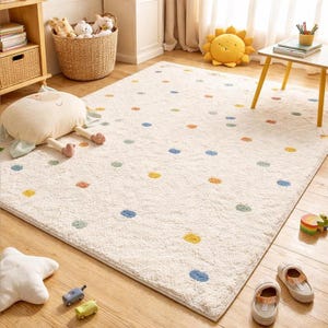 Può includere: Un tappeto rettangolare color crema con un motivo a pois giocoso in vari colori. Il tappeto è realizzato in un materiale morbido e felpato, adatto per la cameretta dei bambini o la sala giochi. Il tappeto è posato su un pavimento in legno.
