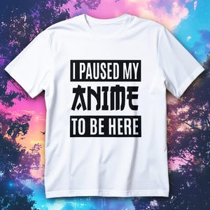 Puede incluir: Camiseta blanca con el texto negro "I PAUSED MY ANIME TO BE HERE" en bloques rectangulares. Una prenda casual, ideal para los aficionados al anime.