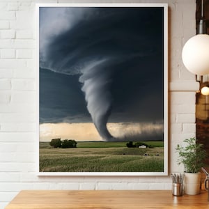 Può includere: Stampa incorniciata di un potente tornado che scende su un campo verde. Il cielo è pieno di nuvole temporalesche scure e vorticose. Una piccola casa e alberi sono visibili in lontananza, sotto un cielo tinto di giallo.
