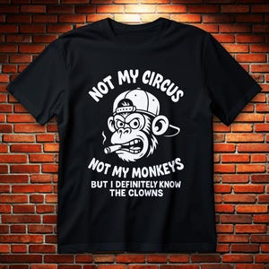 Könnte beinhalten: Schwarzes T-Shirt mit weißer Grafik eines Affen mit Kappe und Zigarre. Der Text lautet: "NOT MY CIRCUS NOT MY MONKEYS BUT I DEFINITELY KNOW THE CLOWNS."