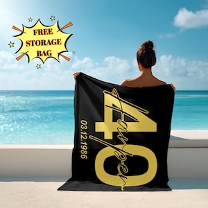 May include: A black beach towel featuring gold text and numbers. The number "40" is the focal point, with the name "Harper" in a script font. The date "03.12.1986" is also visible. A yellow burst graphic with the text "FREE STORAGE BAG" is in the background.