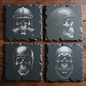 Op de afbeelding: Vier vierkante leistenen onderzetters met schedelontwerpen. Eén schedel draagt een gasmasker, twee dragen helmen en één heeft een ketting om zijn nek. De afbeeldingen zijn in grijstinten, tegen een donkere achtergrond.
