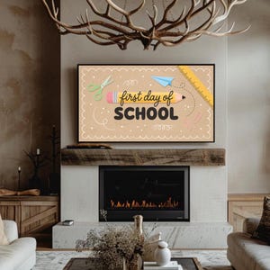 May include: A rectangular digital display featuring a tan background with a scalloped border. The text "first day of SCHOOL" is centered, accompanied by illustrations of a yellow pencil, green scissors, a blue paper airplane, and a yellow ruler.