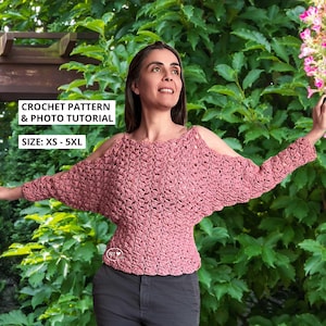 以下が含まれることがあります： 肩出しと長袖のダスティローズのかぎ針編みトップス。トップスはテクスチャードステッチパターンが特徴です。「CROCHET PATTERN & PHOTO TUTORIAL」と「SIZE: XS - 5XL」の文字が見えます。モデルは緑の葉の前で立っています。