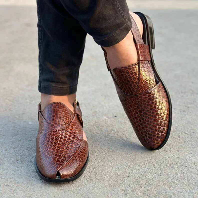 May include: Brown leather sandals with a woven texture. The sandals have a closed-toe design with a strap across the top of the foot and around the ankle. The soles are black.