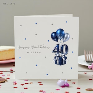 May include: A white square birthday greeting card featuring the text Happy Birthday WILLIAM and the number 40 in blue. The design includes a cluster of blue and silver balloons, a blue gift box with a silver ribbon, and scattered blue gems.