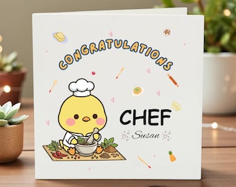 Puede incluir: Tarjeta de felicitación blanca con el texto "¡Enhorabuena Chef!" y un pollito de dibujos animados con gorro de chef. El pollito sostiene un mortero y una maja. Fondo de mesa de madera.