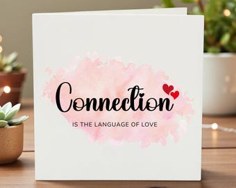 Puede incluir: Tarjeta de felicitación blanca con la palabra "Connection" en escritura negra sobre un fondo rosa acuarela. Dos corazones rojos están a la derecha de la palabra. La frase "IS THE LANGUAGE OF LOVE" está debajo.