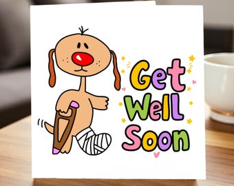 May include: A white greeting card with a cartoon dog with a bandaged leg and a crutch. The card has the words "Get Well Soon" in colorful letters, with stars and hearts.