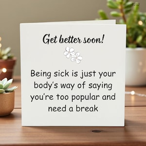 May include: A white card with the words "Get better soon!" in black script. The card has a floral illustration and a humorous get-well message: "Being sick is just your body's way of saying you're too popular and need a break."