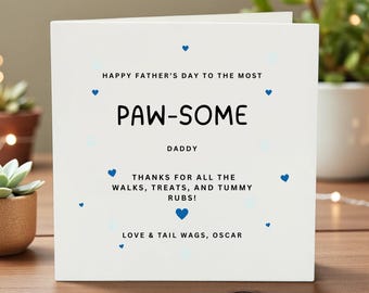 May include: A white Father's Day card with blue heart accents. The card reads "Happy Father's Day to the Most Paw-some Daddy." Additional text includes "Thanks for all the walks, treats, and tummy rubs!" and "Love & tail wags, Oscar."
