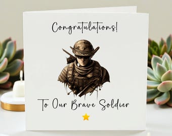 Op de afbeelding: Witte wenskaart met de tekst "Gefeliciteerd!" en "Aan onze dappere soldaat". De kaart toont een illustratie van een soldaat in uniform. Onder de tekst staat een gele ster.