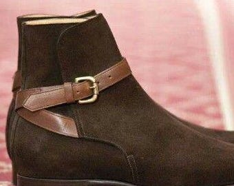May include: A pair of dark brown suede ankle boots with a leather strap and buckle detail. The boots have a low heel and a classic design, suitable for various occasions.