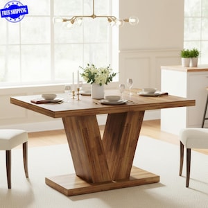 May include: A rectangular wooden dining table with a V-shaped base. The table is set with white plates, bowls, and silverware. A vase of white flowers sits in the center. The table is approximately 60 inches long.