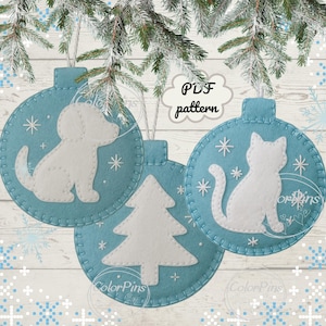 May include: Three pale blue felt Christmas decorations with white felt cutouts of a dog, cat, and Christmas tree. Each bauble has a stitched border and snowflake details. The text "PDF pattern" is in a cloud-shaped bubble.