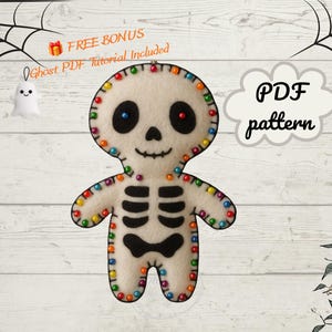 Könnte beinhalten: Eine Skelettpuppe aus Filz mit schwarz gestickten Augen, Nase, Mund und Rippen. Die Ränder sind mit bunten Perlen verziert. Der Text auf dem Bild lautet: FREE BONUS Ghost PDF Tutorial Included und PDF pattern.