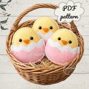 May include: A woven basket holds three felt Easter chicks, each emerging from a pink and white eggshell. The chicks are yellow with orange beaks and black eyes. The image includes the text "PDF pattern".