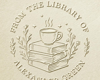 May include: A cream-colored embossed design featuring a stack of books, a steaming coffee cup, and botanical elements. The text reads "FROM THE LIBRARY OF ALEXANDER GREEN" in a circular arrangement, suggesting a bookplate or library stamp.
