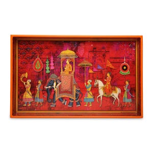 Puede incluir: Una bandeja rectangular con marco naranja que presenta una vibrante ilustración roja de una procesión real. La escena muestra a una figura montada en un elefante, otra en un caballo blanco y varios asistentes portando estandartes e instrumentos.