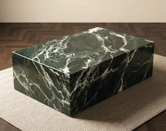May include: A rectangular coffee table constructed from solid dark green marble with prominent white veining. The piece features a smooth, polished surface and sharp, clean edges, forming a block-like structure with a flat top and vertical sides.