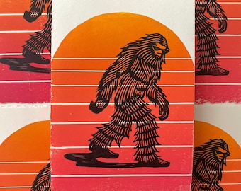 May include: A set of four black and white illustrations of a Bigfoot walking across a red and orange sunset background. The illustrations are printed on white paper.
