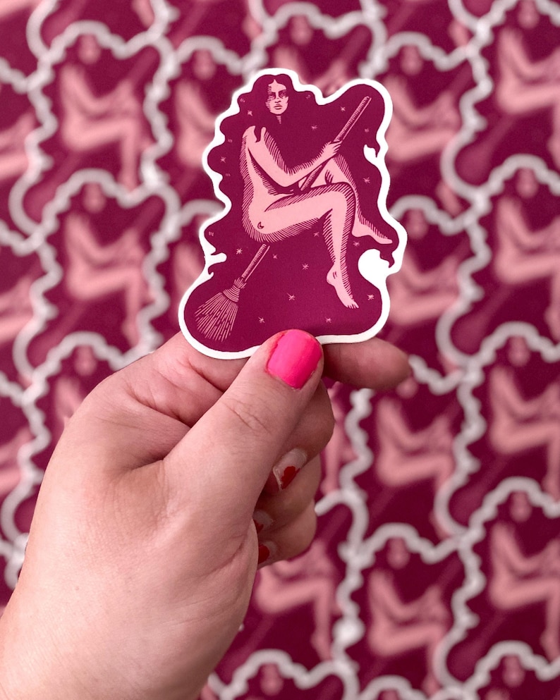 A pink and purple vinyl sticker featuring a witch riding a broomstick