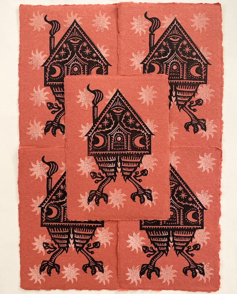 May include: Five black and white linocut prints of a house with a chimney and legs on a pink background with white stars.