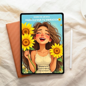 Peut inclure: Une tablette numérique avec une illustration colorée d'une femme souriante tenant des tournesols. Le texte en espagnol sur la tablette dit : "DIARIO DE 28 DIAS PARA ELEVAR TU VIBRACION" et "Despierta tu Pureza Interior con Gratitud". Un carnet pêche et un stylet blanc sont également visibles.