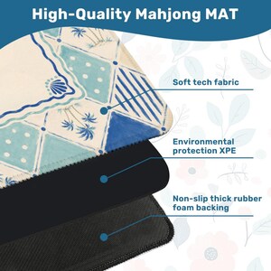 May include: A high-quality Mahjong mat with a cream and blue geometric design. The mat features a soft tech fabric, environmental protection XPE, and a non-slip thick rubber foam backing. The text "High-Quality Mahjong MAT" is at the top.