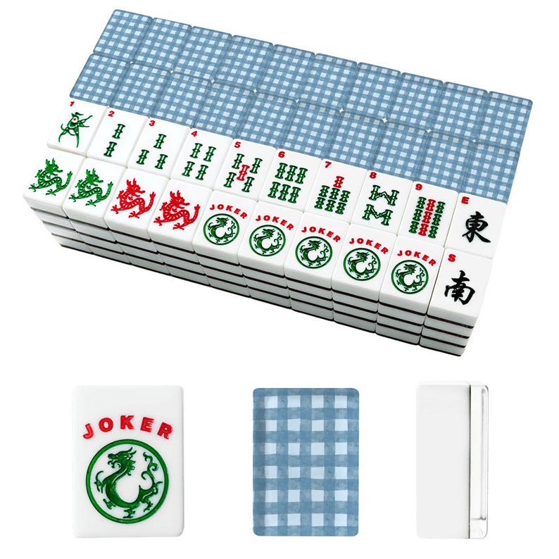 May include: A complete Mahjong set with white tiles featuring green and red dragon designs, Chinese characters, and the word "JOKER." The set includes blue-checkered card-like pieces. The tiles are stacked neatly, ready for play.