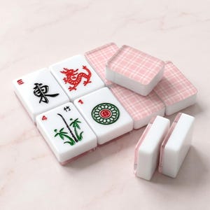 May include: A collection of white Mahjong tiles with red, green, and black symbols. Some tiles display a red dragon, bamboo, and a circular design. The set includes pink plaid-patterned tiles.