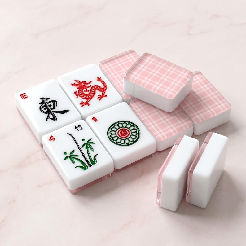 May include: A collection of white Mahjong tiles with red, green, and black symbols. Some tiles display a red dragon, bamboo, and a circular design. The set includes pink plaid-patterned tiles.