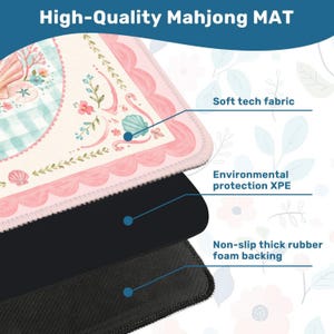 May include: A high-quality Mahjong mat with a soft tech fabric surface, featuring a pink scalloped border and a whimsical design with seashells and flowers. The mat has a non-slip thick rubber foam backing for stability.