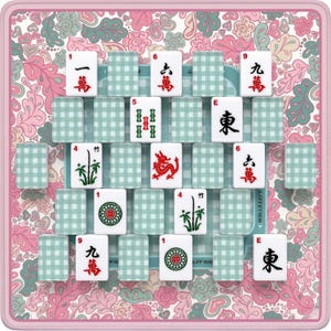 K&ouml;nnte beinhalten: Ein Mahjong-Set mit wei&szlig;en Spielsteinen mit chinesischen Schriftzeichen und Symbolen, angeordnet auf einer floral gemusterten Matte. Die Matte hat einen rosa Rand und ein hellblaues und rosa Blumenmuster. Die Spielsteine sind in einem Raster angeordnet.
