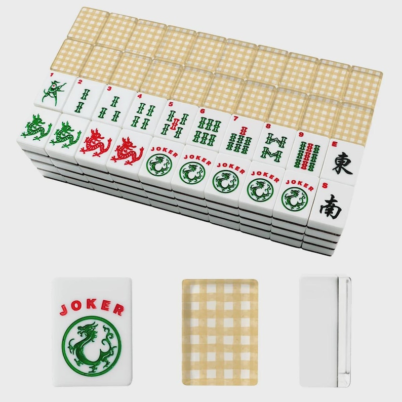 May include: A complete Mahjong set with white tiles featuring green and red dragon designs, Chinese characters, and the word "JOKER." The set includes a stack of tiles, a single "JOKER" tile, a beige checkered tile, and a white tile.