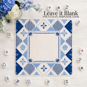 Op de afbeelding: Een vierkante placemat met een blauw en wit tegelontwerp en een centrale lege ruimte. Het patroon bevat geometrische vormen, bloemmotieven en schelpmotieven. De tekst "Leave it Blank" is zichtbaar. Mahjong-tegels zijn verspreid.