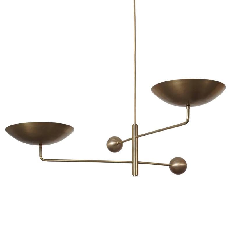 May include: A modern brass chandelier with two bowl-shaped shades and three spherical accents. The fixture hangs from a single rod, with the shades extending horizontally. The design is minimalist and elegant, suitable for various interior styles.