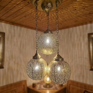 Close up of a gold Moroccan brass pendant light with intricate hand-pierced patterns.