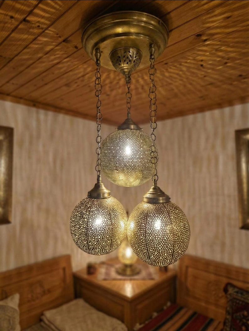Close up of a gold Moroccan brass pendant light with intricate hand-pierced patterns.