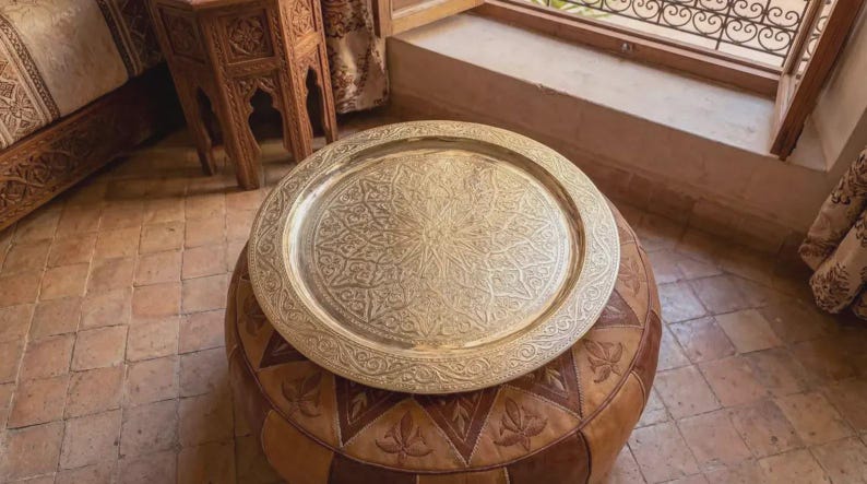 "Engraved brass tray hanging on a white wall as a piece of statement art."