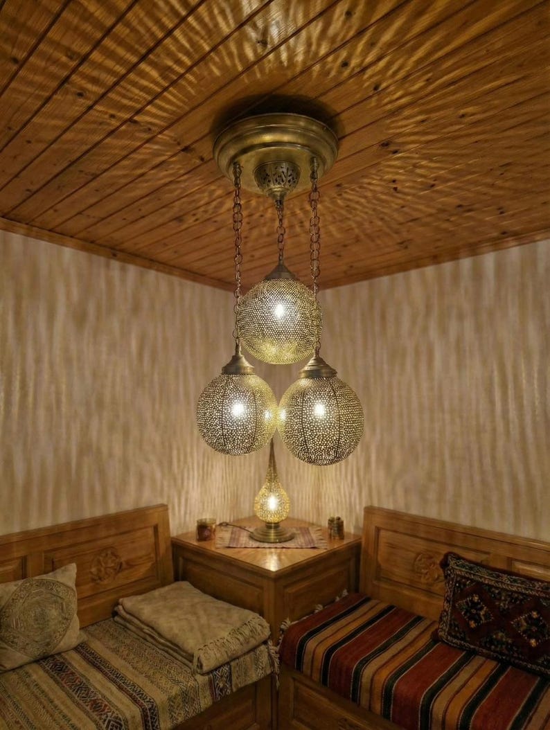 The brass globe lamp shown unlit, highlighting its golden metallic sculpture-like form.