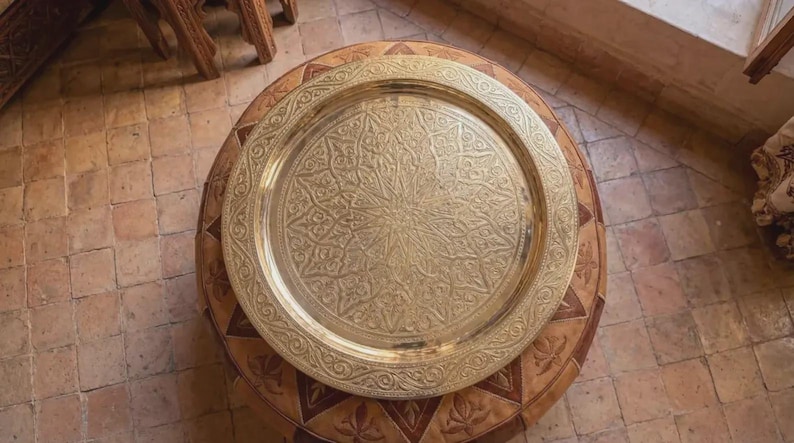 "Close-up of hand-etched Arabesque details on a gold brass serving platter."