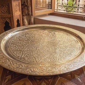 "A stack of various sized Moroccan brass trays showing craftsmanship variety."