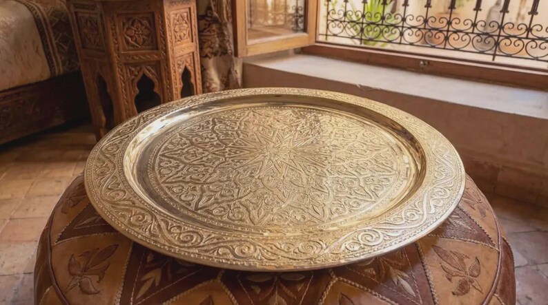 "A stack of various sized Moroccan brass trays showing craftsmanship variety."