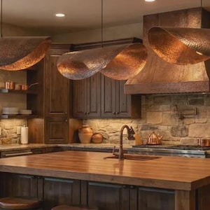 May include: A rustic kitchen with copper pendant lights, a wooden island, and dark wood cabinetry. The kitchen features a copper range hood, copper pots, and a stone backsplash, creating a warm and inviting atmosphere.